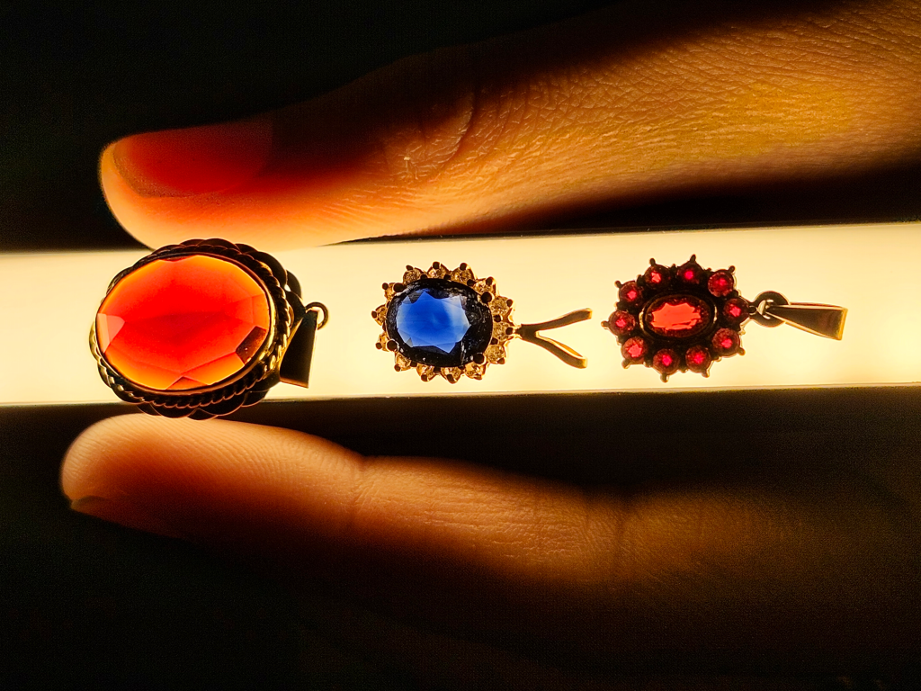 A Garnet, sapphire, and Ruby pendant glowing under a light